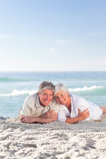 Couple d&#39;âge mûr allongé sur la plage