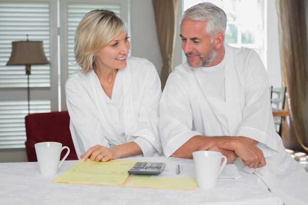 Couple d&#39;âge mûr décontracté avec factures maison et calculatrice