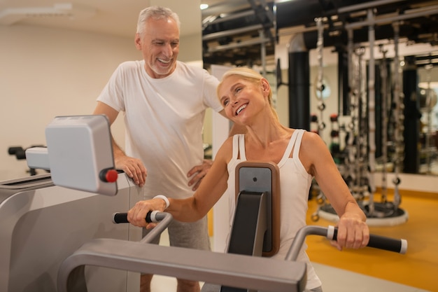 Couple d'âge mûr exerçant ensemble dans la salle de sport et se sentir bien