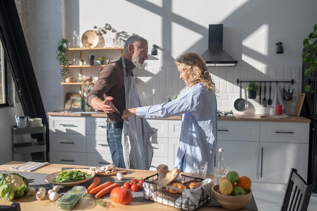 Couple d'âge mûr se sentant bien en cuisinant ensemble dans la cuisine