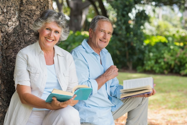 Couple d&#39;âge mûr souriant, lire des livres ensemble