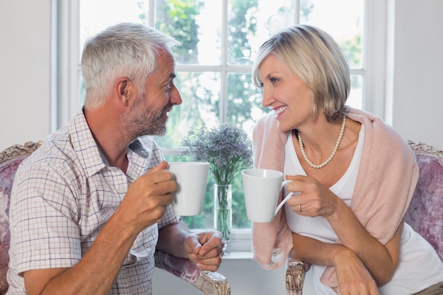 Couple d&#39;âge mûr avec des tasses de café à la maison