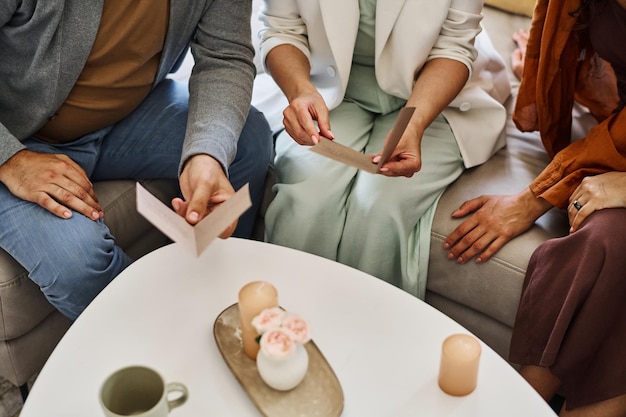 Photo couple d'âge mûr en vêtements décontractés intelligents assis sur un canapé et lisant des cartes d'invitation