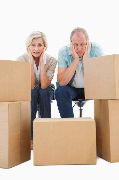 Couple âgé stressé avec des boîtes de déménagement