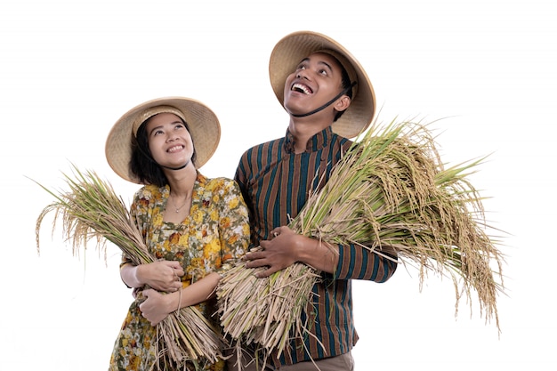 Couple d'agriculteurs asiatiques tenant des grains de riz