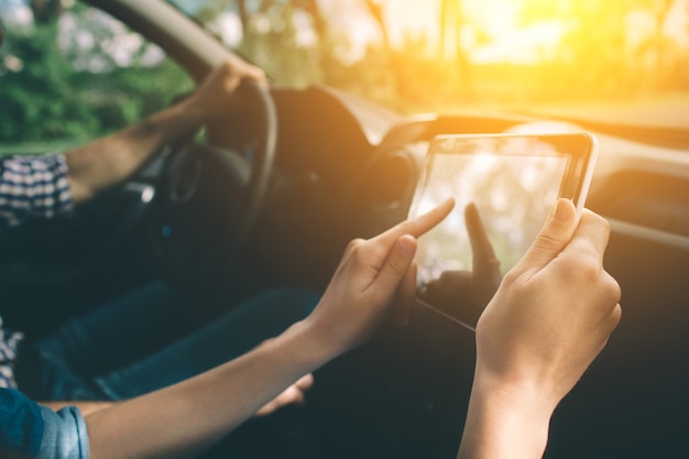 Couple à l'aide de gps sur tablette compter pour naviguer en voiture en vacances