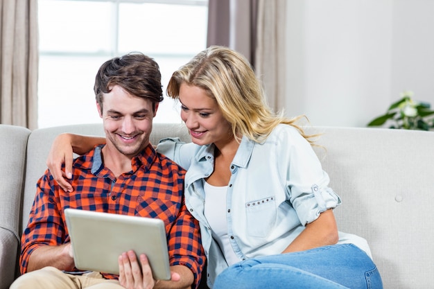 Couple à l&#39;aide d&#39;une tablette sur le canapé