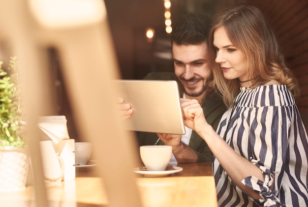 Couple à l'aide d'une tablette numérique dans un café-restaurant