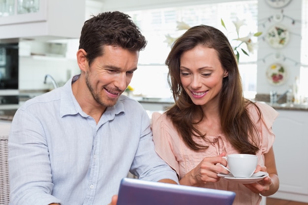 Couple à l&#39;aide de tablette numérique tout en prenant un café