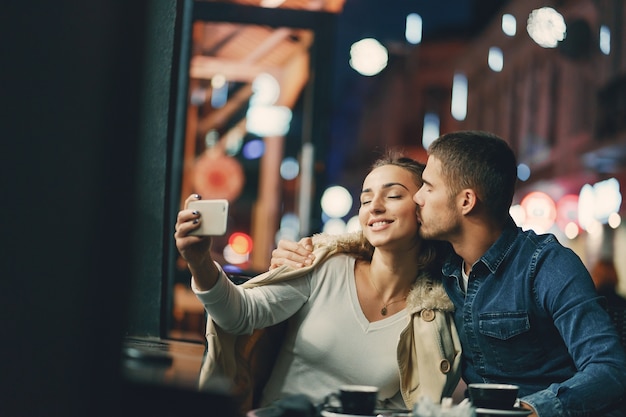 Photo couple à l'aide de téléphone dans un café