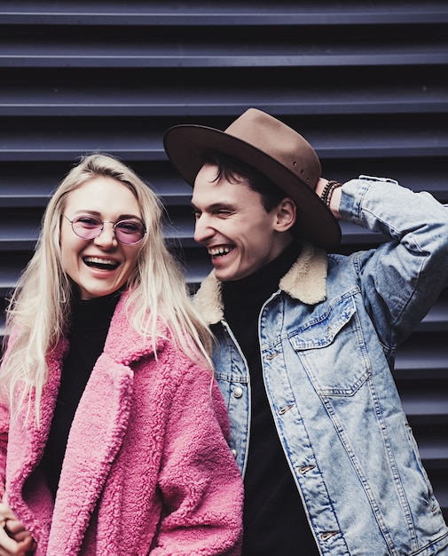 Couple aimant, femme blonde à lunettes et homme au chapeau en riant