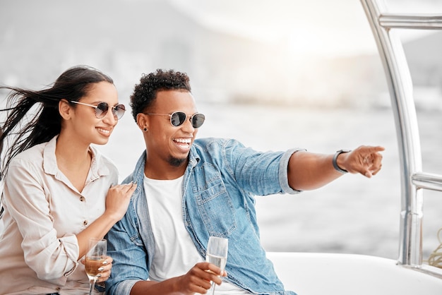 Un couple aime voyager sur un yacht de luxe en mer ensemble lors d'un rendez-vous romantique dans la nature pendant des vacances Sourire heureux et jeune petit ami et femme savourent du champagne dans l'océan lors d'une croisière en bateau