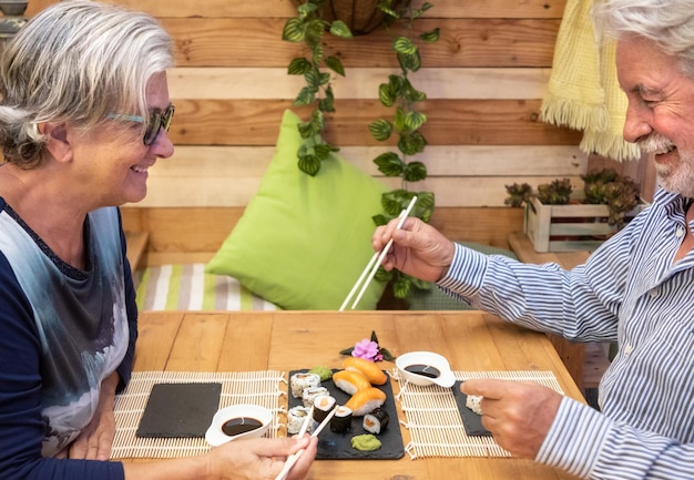 Photo un couple d'aînés qui mangent des sushis.