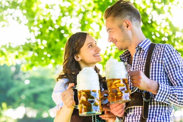 Photo couple allemand en tracht buvant de la bière