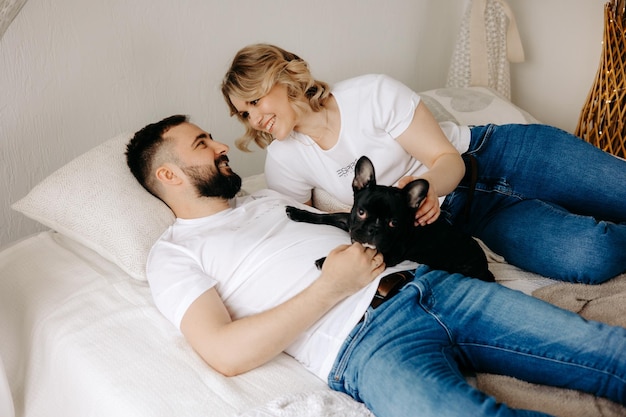 Couple allongé sur un lit avec leur chien