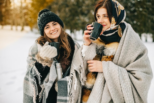 Couple d'amis avec boisson chaude en hiver