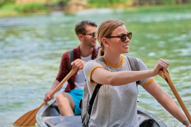 Photo un couple d'amis explorateurs aventureux fait du canoë dans une rivière sauvage entourée par la belle nature