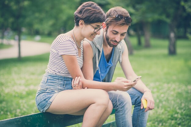 couple d&#39;amis jeune homme et femme à l&#39;aide de smartphone