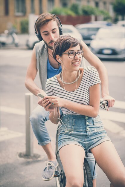 couple d&#39;amis jeune homme et femme équitation vélo