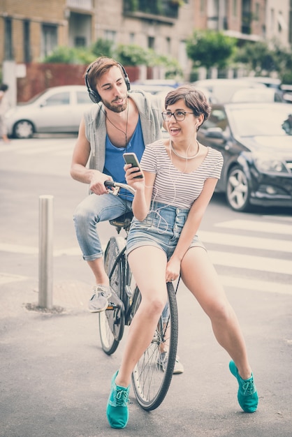 couple d&#39;amis jeune homme et femme équitation vélo