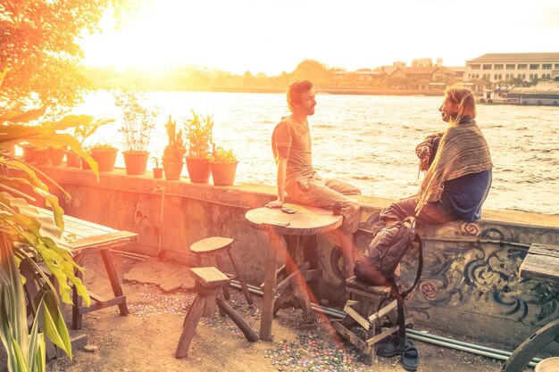 Couple d'amis parlant au coucher du soleil