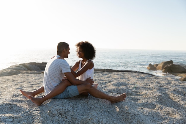 Photo un couple en amour sur le rocher de la plage