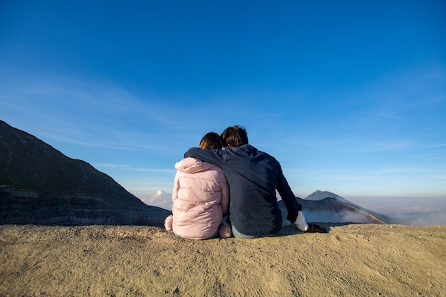 couple amour se sentir heureux assis sur le dessus Kawah ijen, Indonésie à la journée ensoleillée