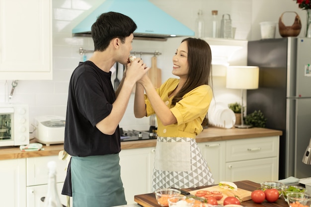 Photo couple amoureux aidant à cuisiner dans une ambiance romantique