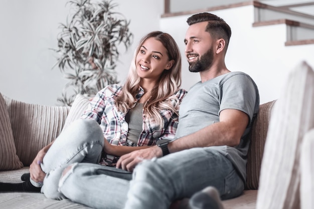 Couple d'amoureux assis sur un canapé dans un salon confortable