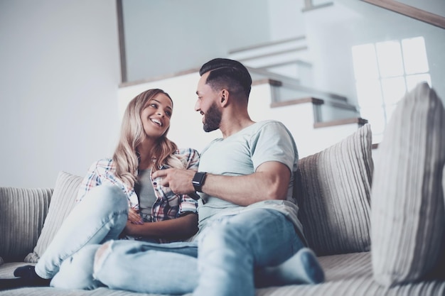 Couple d'amoureux assis sur un canapé dans un salon confortable