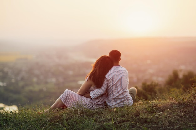 couple amoureux assis sur la colline et regarder le paysage de montagne