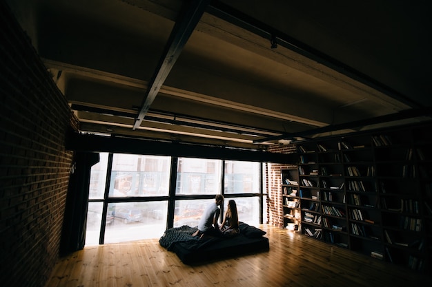 Photo un couple amoureux assis sur un matelas dans un loft.