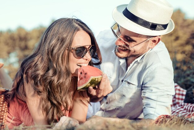 Couple d'amoureux ayant un pique-nique en été