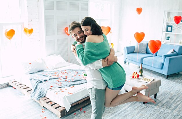 Couple amoureux. Un bel homme et une femme élégants dansent dans la chambre avec un fond romantique