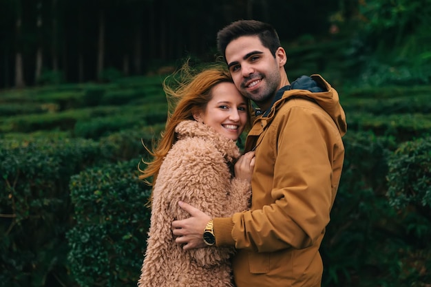 Couple amoureux câlin et regarder dans la caméra de beaux sourires c