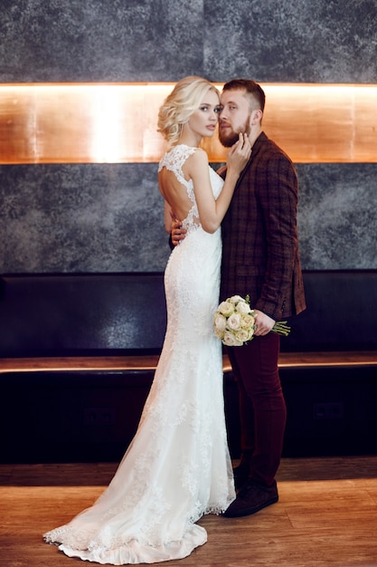 Couple amoureux câlins et bisous le jour de leur mariage. Marié hipster et la mariée, amour et loyauté. Le couple idéal se prépare à devenir mari et femme. Homme et femme se regardant de près