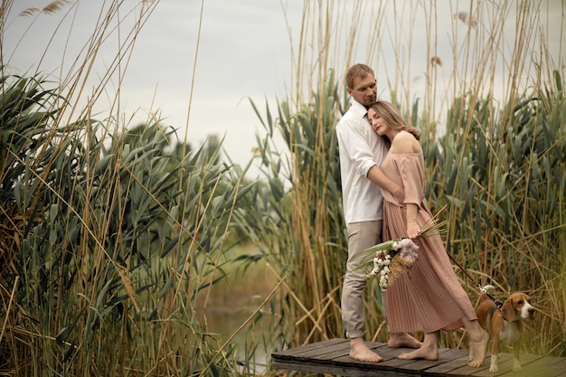 Couple amoureux câlins et s'embrasser à une jetée en bois à la nature.