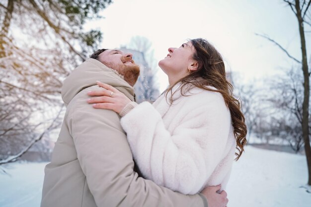 Un couple amoureux sur un champ d'hiver enneigé heureux ensemble