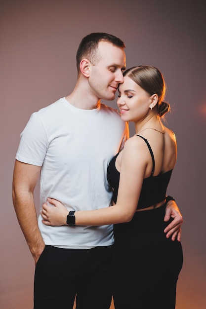 Un couple amoureux en chemises blanches s'embrassent et s'amusent Un couple élégant s'embrasse sur fond blanc Concept de famille heureuse