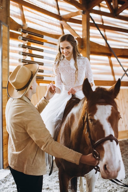 Couple amoureux à cheval sur ranch au coucher du soleil en hiver