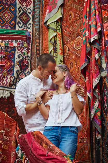 Couple amoureux choisit un tapis turc au marché. Émotions joyeuses et joyeuses sur le visage d'un homme et d'une femme. Saint Valentin en Turquie