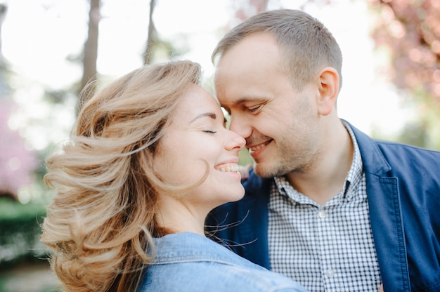 Couple amoureux dans un verger de pommiers en fleurs allongé sur la couverture