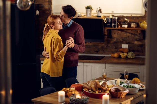 Couple d'amoureux dansant dans la salle à manger à Thanksgiving