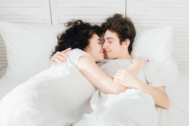 Couple amoureux dort câlins au lit