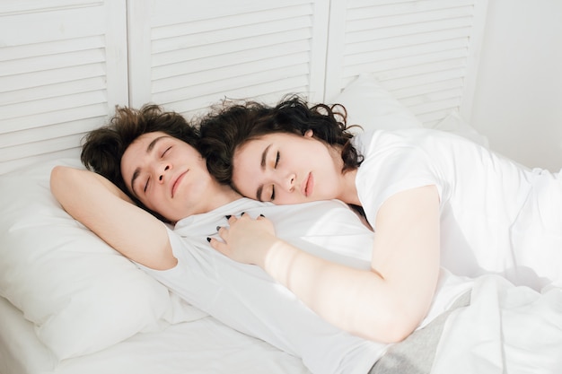 Couple amoureux dort câlins au lit