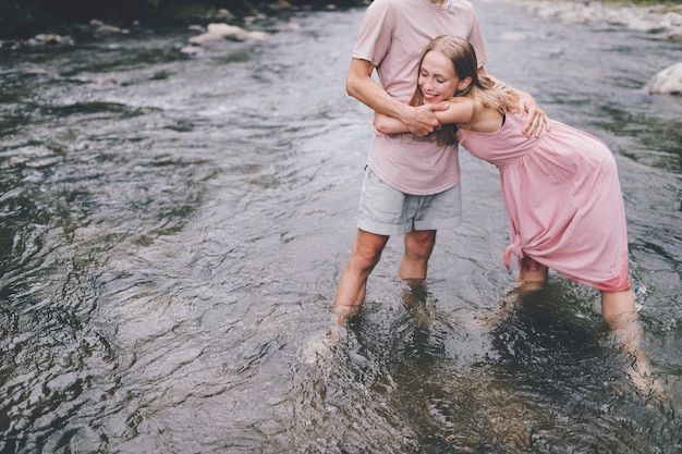 couple d'amoureux drôle étreindre dans la rivière.