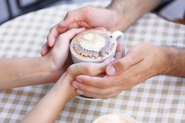 Couple d'amoureux avec du café chaud sur la table au café