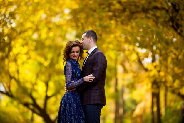 Couple amoureux, embrassant l'automne dans les bois