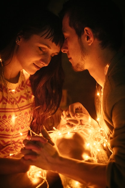 Couple amoureux embrassant la nuit avant Noël