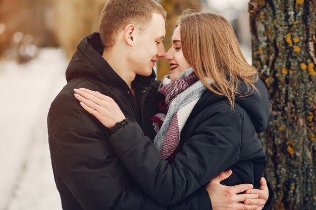 couple d&#39;amoureux, encerclant dans un parc enneigé